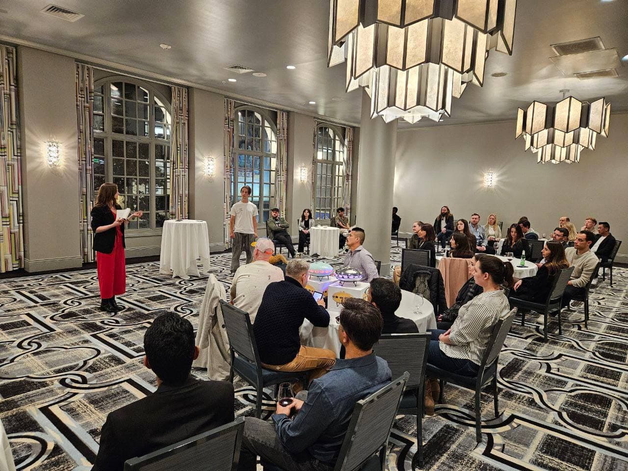 Host on stage in a ballroom at a Startup Valley pitch night